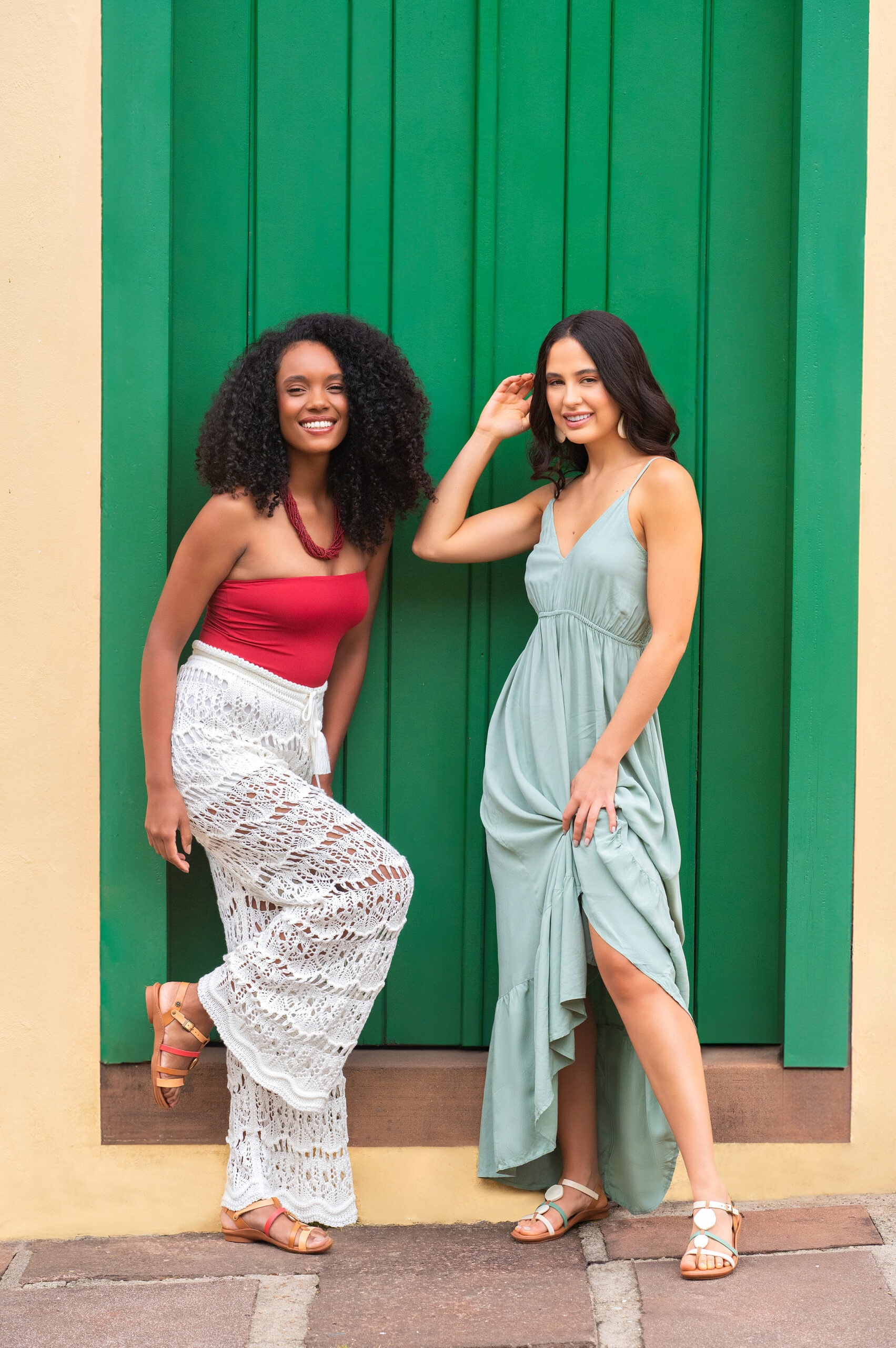 Duas mulheres sorrindo, usando sandálias e rasteiras de couro da New Face Calçados